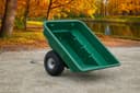 ATVCG ATV trailer green plastic tub tilted upward showing dump position, single wheel view