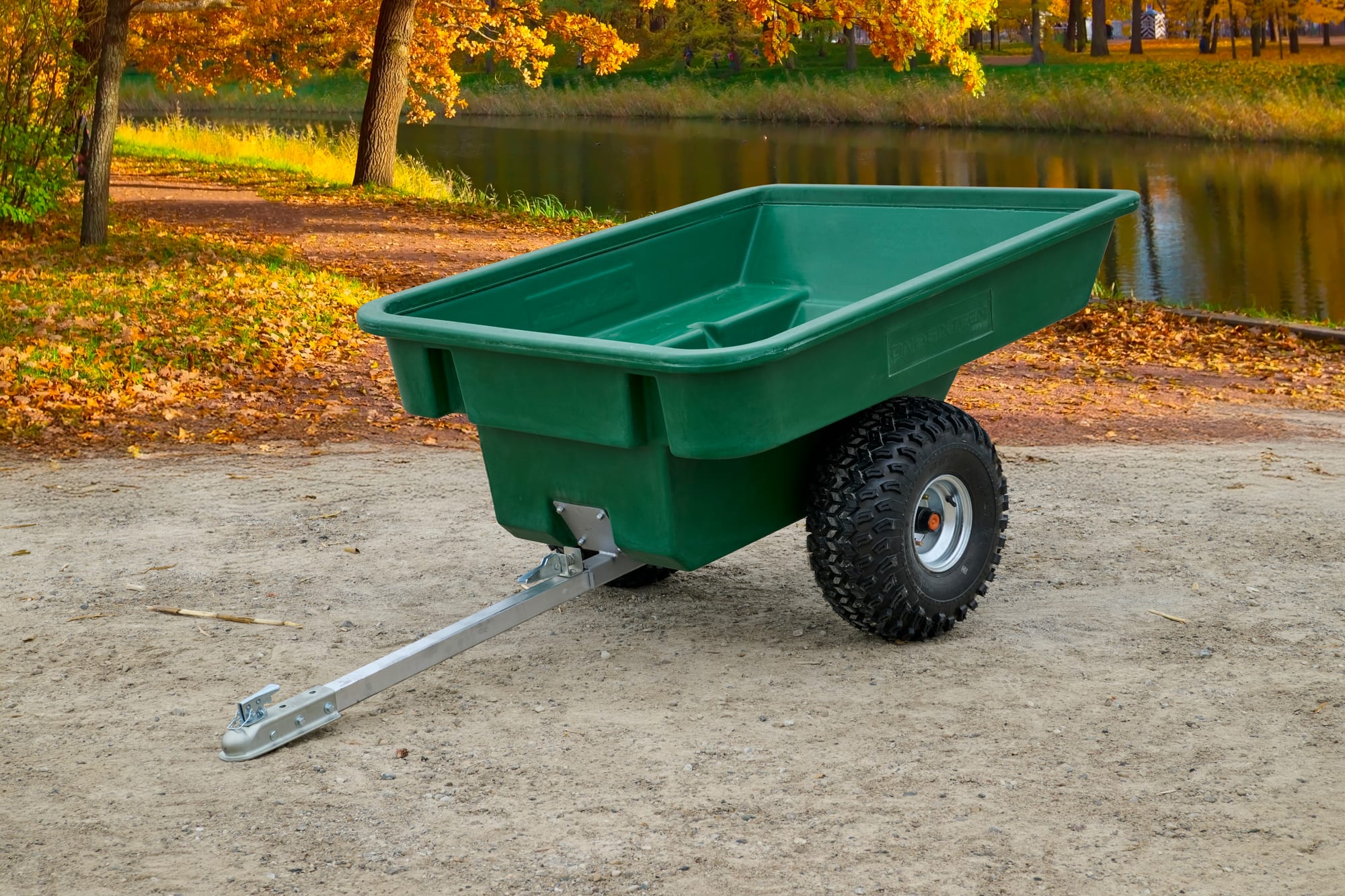 ATV Trailers green plastic utility trailer with single axle and tow hitch, full side view outdoors